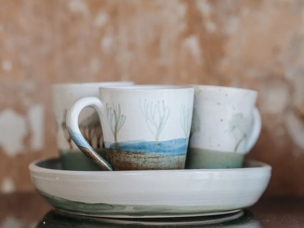 Mug putih bergambar ombak biru di dalam mangkuk lebar